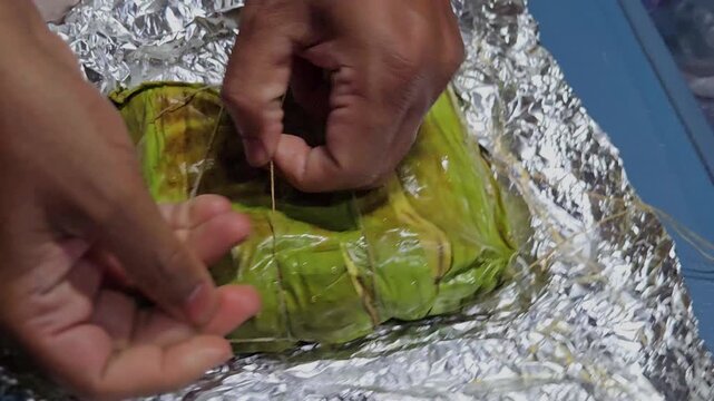 Kizhi Parotta: flaky bread layered with spicy meat gravy, bundled in banana leaf and steamed. This popular South Indian train meal is unwrapped to reveal a fragrant, flavor-soaked, & delicious delight