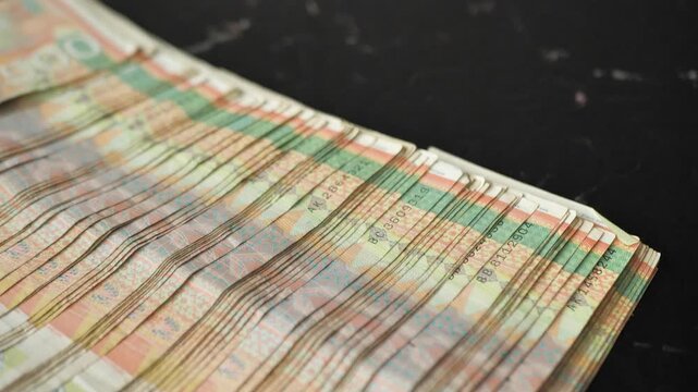 Large amount of Serbian dinars banknotes in denomination five hundred falling on table and spreading over surface of table. Serbian banknotes in large quantity. Concept of cash money. Corruption