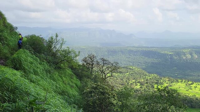 Beautiful scenic view of trekkers and the deep valley at Madhe Ghat in stunning 4K, where the Western Ghats of Maharashtra glow with mist, greenery, and adventure.