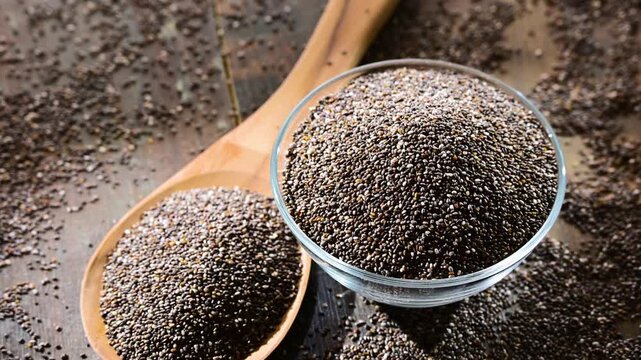 Bowl of chia seeds on wooden table.