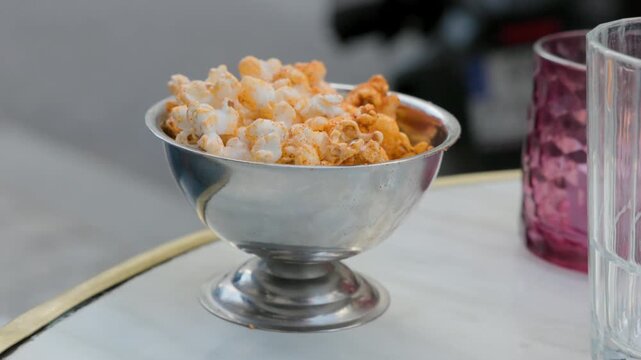 Close-up of Seasoned Popcorn in Metal Bowl Served at a Parisian Cafe Terrace at Happy Hour