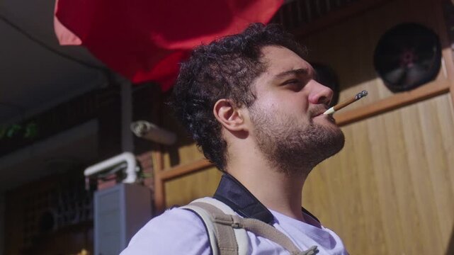 Young man smoking a thin cigar