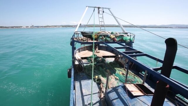 Fish trawlers navigate back to port after a day's work at sea. Their return reminds us of the need for ocean conservation and the balance between fishing and protecting marine life.