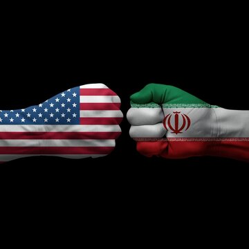 A symbolic image of conflict between the United States and Iran, represented by fists with their respective national flags.