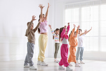 Professional dance teacher training children in studio