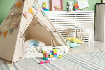 Cute wigwam and building blocks in stylish child's room © New Africa