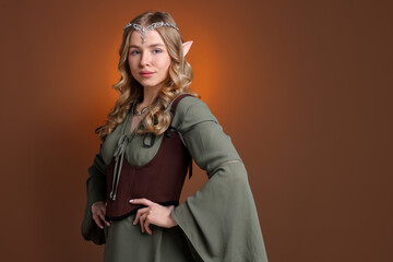 Fototapeta premium Portrait of beautiful elf girl on brown gradient background