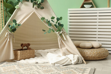 Cute wigwam with leaves and blanket in stylish child's room © New Africa