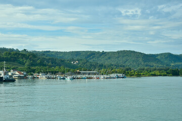 Fototapeta premium Wide coastal view of Kampung Nelayan Tradisional di Bakauheni, Selat Sunda, Lampung, Indonesia. Ideal for travel, marine industry, and banner background.