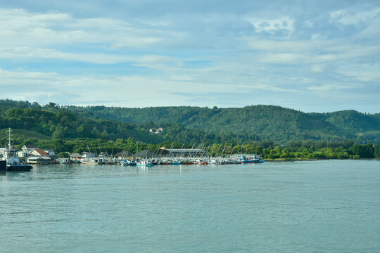 Wide coastal view of Kampung Nelayan Tradisional di Bakauheni, Selat Sunda, Lampung, Indonesia. Ideal for travel, marine industry, and banner background.