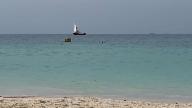 Dhow sailboat horizon swimmer turquoise ocean Zanzibar