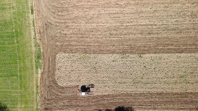 Aerial Drone View of Tractor Plowing Agricultural Field with Patterned Farmland