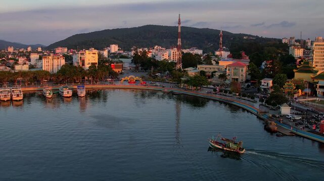 Aerial view of busy port of Duong Dong town with boats returning from a long day of fishing at sunset golden hour sun going down on the horizon Phu Quoc Island in South Vietnam