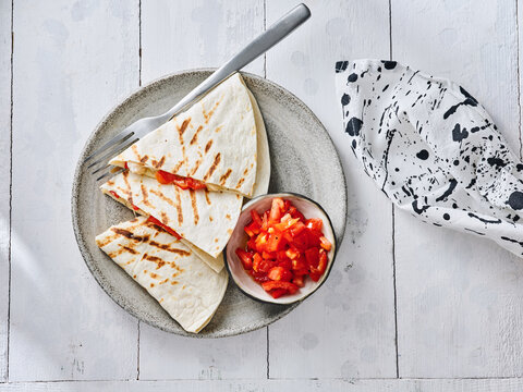 The image shows grilled quesadilla slices served with a side of fresh salsa. This dish is perfect for restaurant menus, food blogs, and social media content