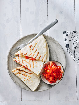 The dish features grilled quesadillas served with a side of fresh salsa in a bowl. Ideal for restaurant menus, food blogs, social media posts, and casual dining promotions