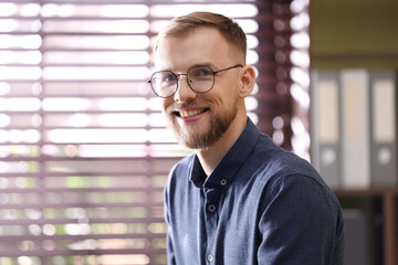 Fototapeta premium Portrait of smiling man in glasses in office