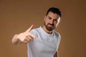 Fototapeta premium Resentment. Portrait of angry man on beige background