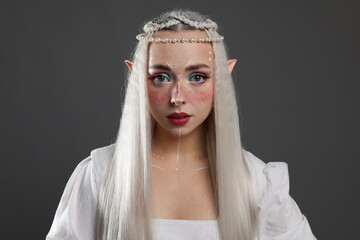 Naklejka premium Beautiful girl dressed as elf on grey background