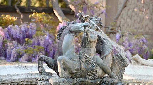 Putto riding a horse fountain decoration in a park