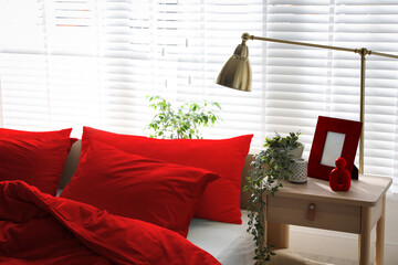 Red bedding on bed and decorative elements in room