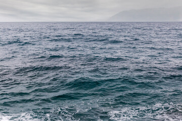 Fototapeta premium Water surface near the sea shore in overcast rainy weather