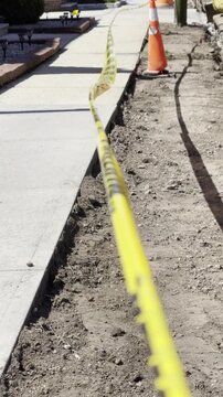 throwing caution to the wind. Blowing caution tape at a construction site of new sidewalks