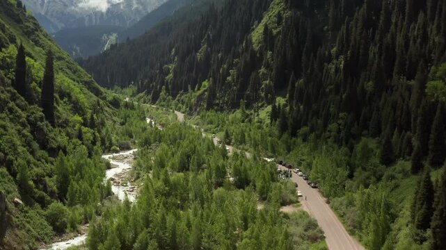 aerial view flying forward over green mountain valley with river and forest, scenic landscape travel concept with untouched nature, exploration adventure and summer wilderness environment