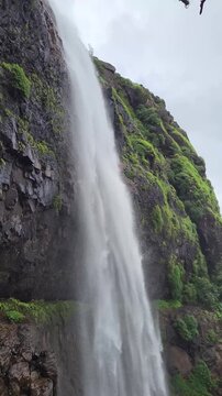 Laxmi Waterfall in stunning vertical slow motion, cascading gracefully through lush Sahyadri cliffs. Every drop captures the raw beauty and calm power of the monsoon season.