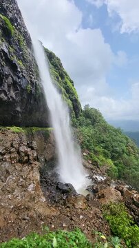 Laxmi Waterfall in stunning vertical slow motion, cascading gracefully through lush Sahyadri cliffs. Every drop captures the raw beauty and calm power of the monsoon season.