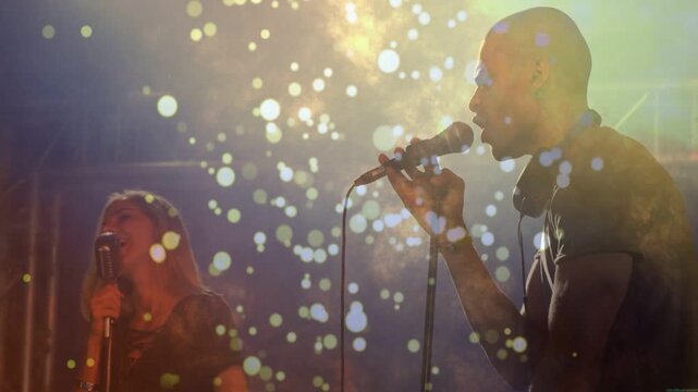 Lead singer starting and gesturing backup singer harmonizing as bokeh wrapping singers for music