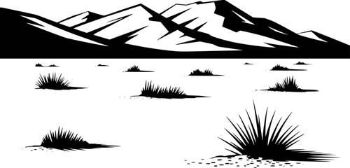 Black and white silhouette of jagged mountain range above sparse desert grass clumps © Mamun