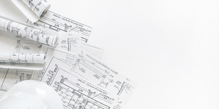 Architecture blueprints with rolled plans, compass and clipboard on desk, construction documentation and engineering design workflow,planning and project management concept, copy space.