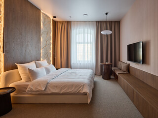 Fototapeta premium Modern and Cozy Hotel Bedroom Interior with Warm Lighting 