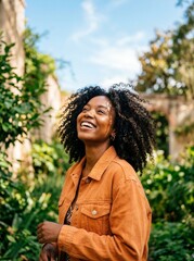 Naklejka premium Joyful young black woman looking up laughing outdoors