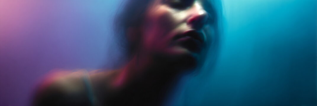 blurred portrait of intoxicated person in blue pink abstract light, psychedelic motion blur face in neon blue and pink aesthetic, surreal drunken human portrait with soft focus and color distortion