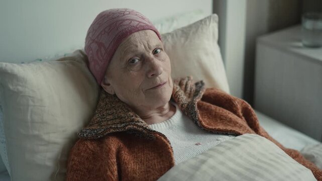 Portrait of elderly bedridden cancer patient in bed