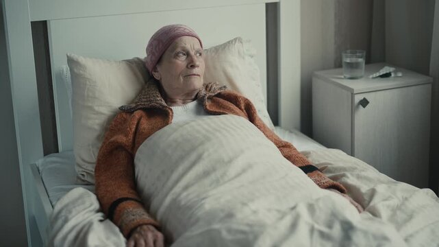 Old woman bedridden with headscarf, sickly appearance