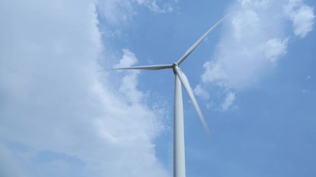 Wind turbine superimposed over a blue patch in the sky generating electiicity on a windy day.