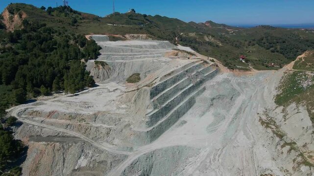 View of a cut hillside prepared for construction in Durres, Albania. Altered terrain, exposed soil layers, urban expansion, environmental impact and land stability concerns in a coastal city.