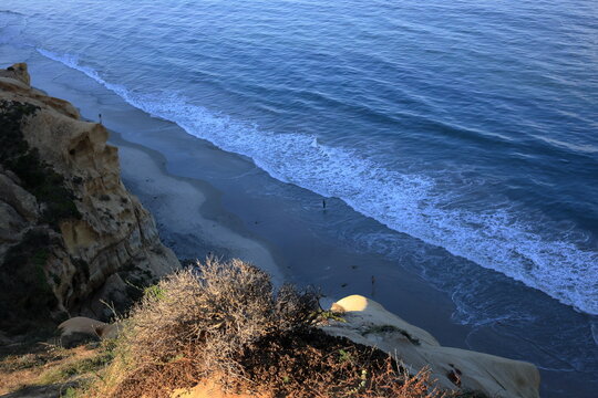 Coastal Cliff View with Waves Rolling onto Sandy Beach Below