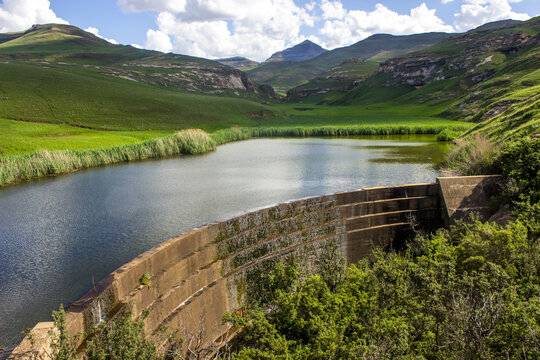 Picturesque view of the overflow at the dam wall of a small reservoir nestled in the Drakensberg Mountains in the Golden Gate Highlands National Park of South Africa