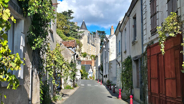 Pretty streets of Montresor in the Loire Valley of France. Picturesque old houses, leafy vines and chateau in the background.