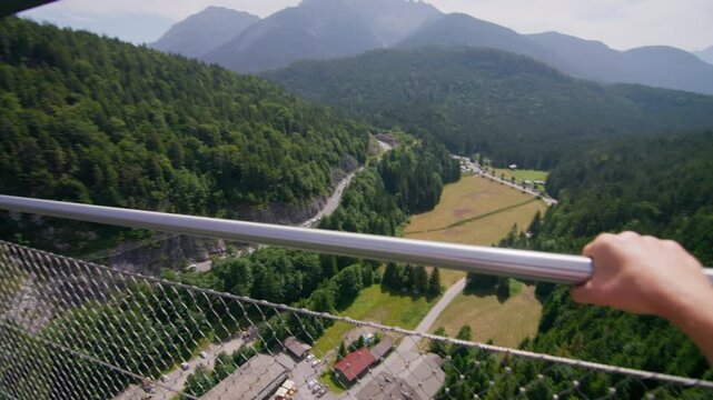 Highline 179 bridge in the Austrian Alps. Tourist walks on a dangerous suspension bridge in the mountains, travel in Europe.