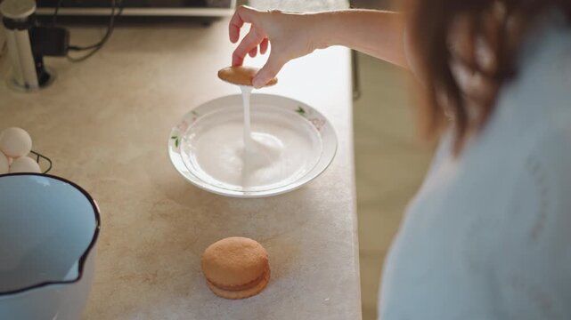 Woman placing filling into pie shell on glass plate eggs carton in hand neat pie base on countertop enamel jug beside methodical portioning home pastry routine warm morning light closeup