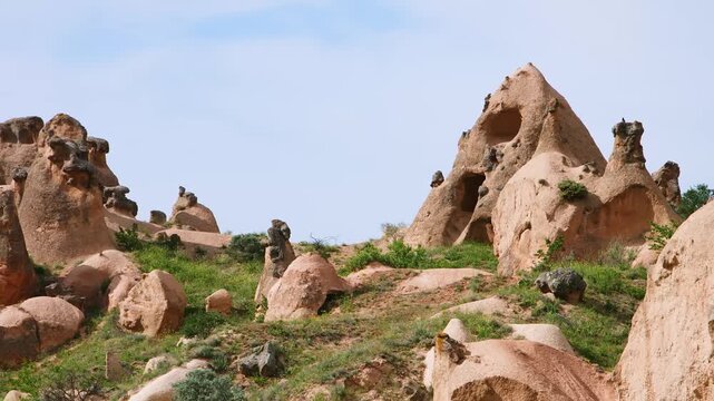A landscape view of the unique volcanic rock formations, known as "fairy chimneys" or hoodoos, in the historic Zelve Valley of Cappadocia, Turkey. The region is a UNESCO World Heritage site known for 