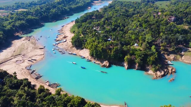 A scenic drone view of the Lalakhal Sari-Goain River in Jaintapur, Sylhet, from above the clear blue sky, which is known as a famous tourist destination in Bangladesh for its clear blue waters.