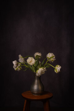 painterly white tulip flowers in vase on stool in renaissance style