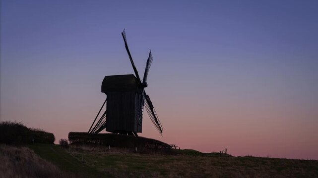 Day to night time lapse clip of the full moon rising behind an old wind mill (Pibe Mill built in 1789) in northern Zealand in Denmark