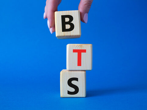 BTS symbol. Wooden cubes with word BTS. Businessman hand Beautiful blue background. BTS concept. Copy space.