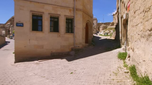 Footage of a deserted street in the old Turkish city of Goreme, Cappadocia. Ancient brick houses with arches and windows are visible against a backdrop of unique eroded tuff fairy chimneys and mountai